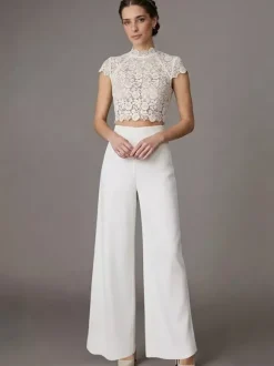 Robe de mariée deux pièces en crêpe stretch décolleté travaillé longueur au sol fermeture éclair manches courtes.