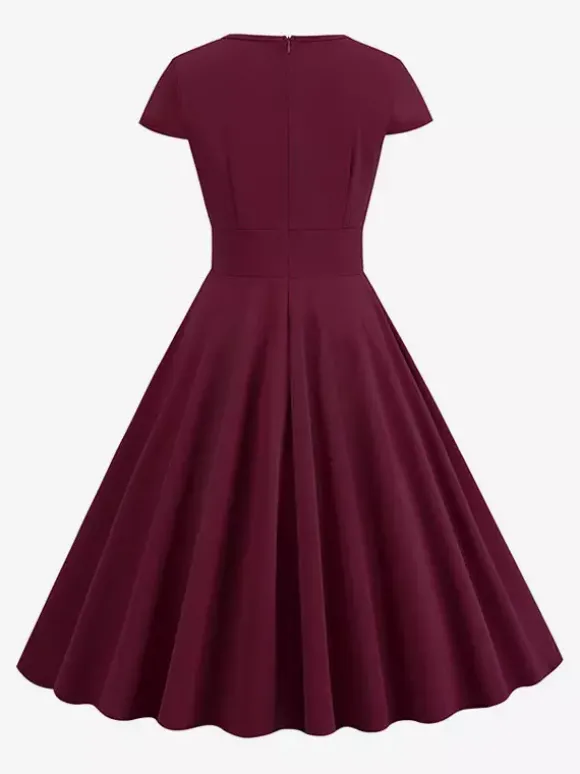 Robe glamour vintage style années 50 col rond manches courtes découpées coupe trapèze moyenne