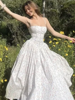 Robe longue bustier à bretelles spaghetti et imprimé floral discret style trapèze idéale pour une soirée romantique.