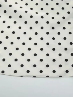 Robe longue crème flatteuse à col en V et pois noirs idéale pour les soirées.