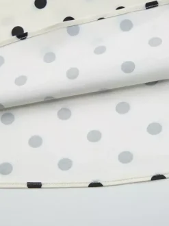 Robe longue crème flatteuse à col en V et pois noirs idéale pour les soirées.