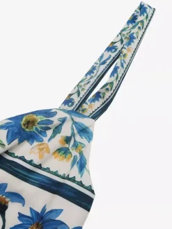 Robe longue d'été fluide à bretelles spaghetti et imprimé floral bleu pour femme avec n艙ud sur le devant et volants.
