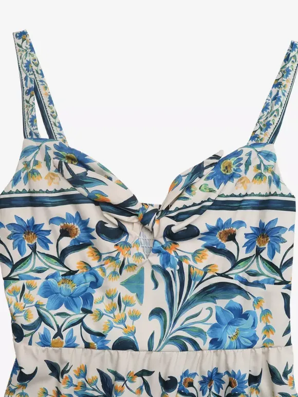 Robe longue d'été fluide à bretelles spaghetti et imprimé floral bleu pour femme avec n艙ud sur le devant et volants.