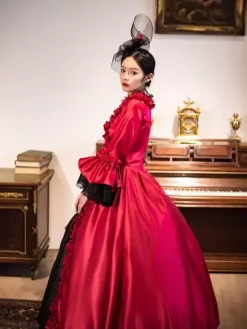 Robe longue rouge rétro victorienne à manches longues évasées style rococo avec coiffe.