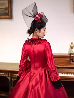 Robe longue rouge rétro victorienne à manches longues évasées style rococo avec coiffe.