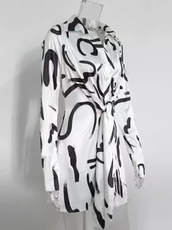 Robe noire élégante à manches longues et coupe asymétrique idéale pour tous les jours.