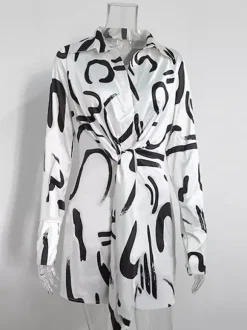 Robe noire élégante à manches longues et coupe asymétrique idéale pour tous les jours.