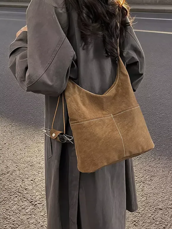 Sac hobo vintage en daim avec surpiqûres contrastées bandoulière ajustable et porte-monnaie intégré.