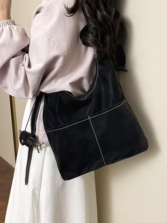 Sac hobo vintage en daim avec surpiqûres contrastées bandoulière ajustable et porte-monnaie intégré.
