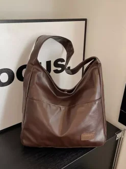 Sac bandoulière hobo minimaliste en similicuir souple grand format en forme de U à porter sous l'aisselle.