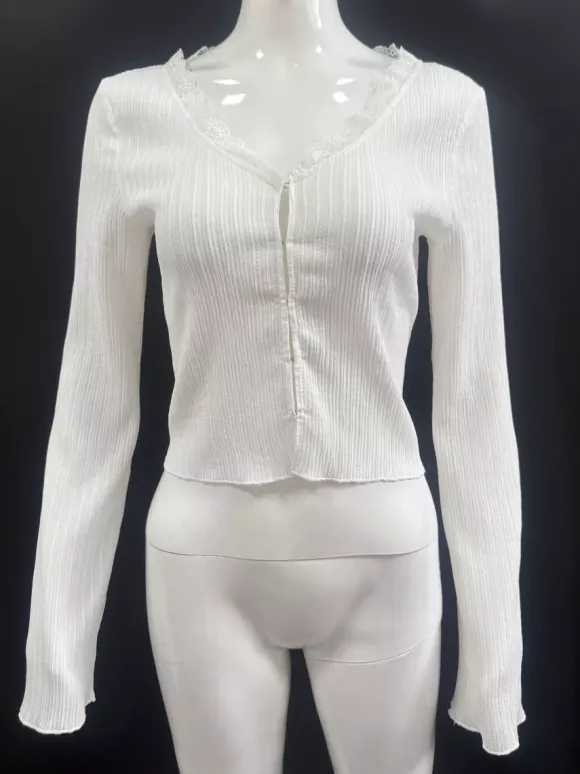 Top en maille côtelée à col en V et manches cloche orné de dentelle collection femme 2026