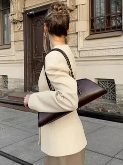 Veste blazer péplum sans manches à col en V et boutonnage nacré à une rangée de boutons.