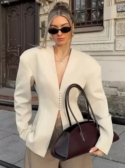 Veste blazer péplum sans manches à col en V et boutonnage nacré à une rangée de boutons.